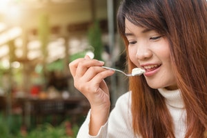 Young woman eating a yoghurt