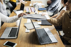 People working at a shared deskspace