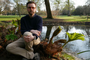 Tomos Jones with a Giant Rhubarb plant in the Harris Gardens at the University of Reading