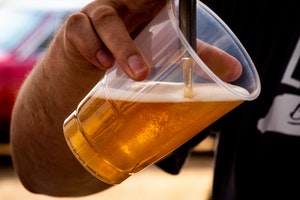 Beer being poured into clear plastic cup