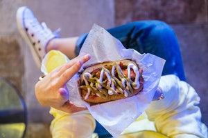 Young woman holding a street food burger