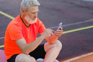 Man dressed in sports wear using his mobile phone