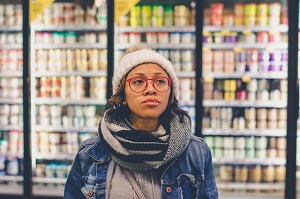 Young woman in a supermarket considering food choices