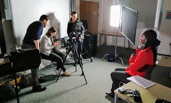 Colour photgraph of teacher being filmed for online course
